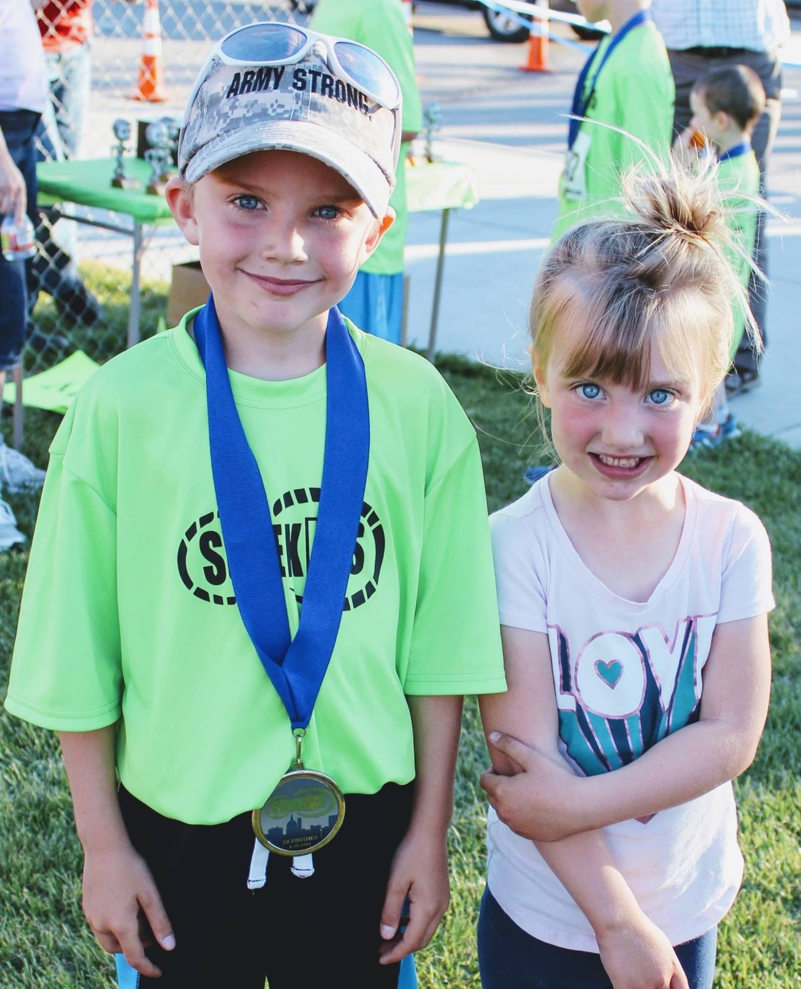 Casey and her brother Colton smiling together after the race, Colton wearing his SoleKIDs 5K finisher's medal